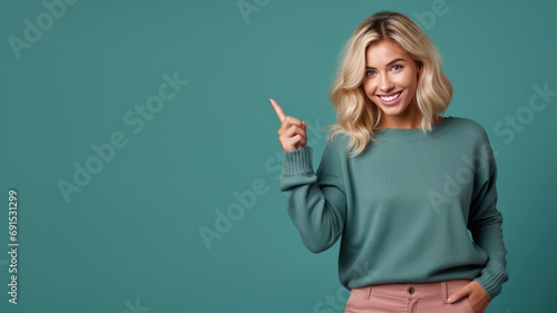 Happy blonde woman pointing her finger at copy space for promotion photo
