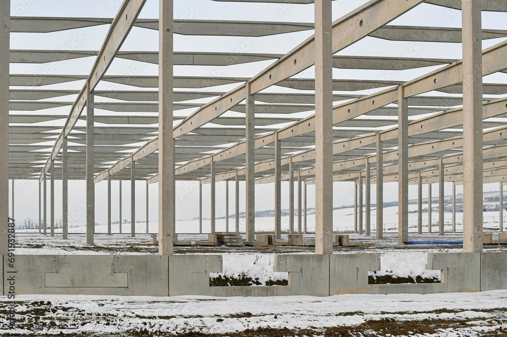 A dismantled plant hall in winter. Building site during winter. The concept of the end of the building season and the end of construction work before winter A dismantled plant hall in winter. Building site during winter. The concept of the end of the building season and the end of construction work before winter