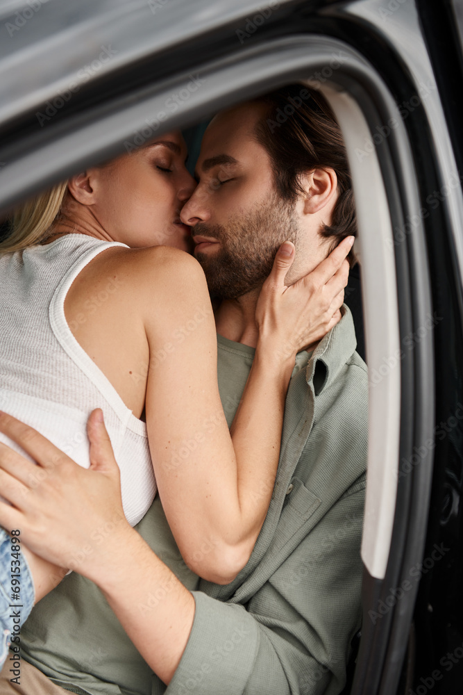 passionate stylish couple embracing and kissing in modern car on city street, love and closeness passionate stylish couple embracing and kissing in modern car on city street, love and closeness