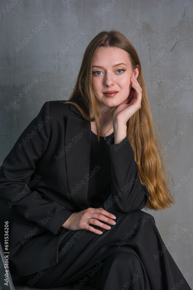 Young beautiful woman, fashion model, in a black suit in the studio Young beautiful woman, fashion model, in a black suit in the studio