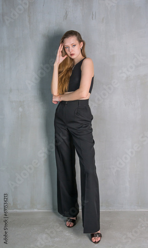 Obraz na płótnie Young beautiful woman, fashion model, in a black suit in the studio w salonie