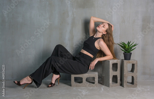 Obraz na płótnie Young beautiful woman, fashion model, in a black suit in the studio w salonie