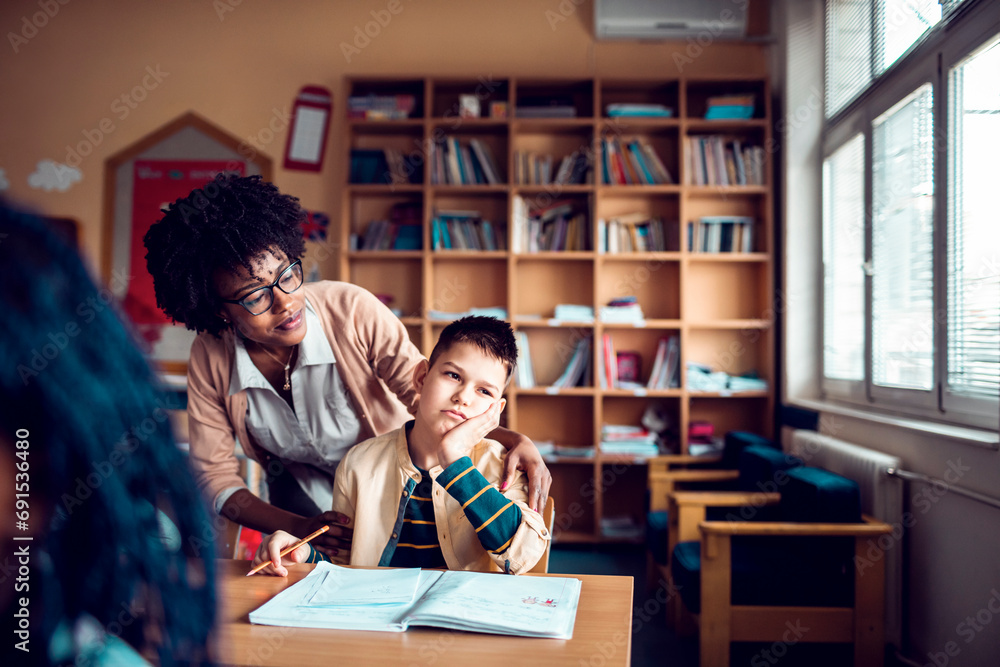 Thoughtful Student with Supportive Teacher in Classroom Thoughtful Student with Supportive Teacher in Classroom