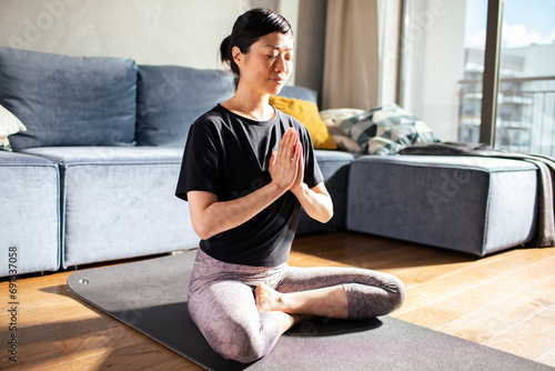 Woman doing yoga at home meditating photo