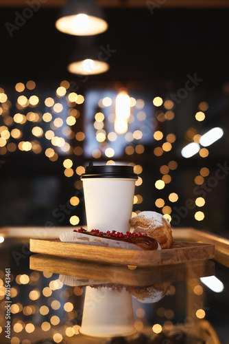 White glass of coffee with eclair on a background of Christmas lights. Mockup. © Лев Малевич
