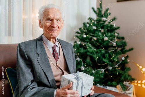 Smiling Joyful Senior Man Holding Christmas Gift In Hands Xmas Holidays