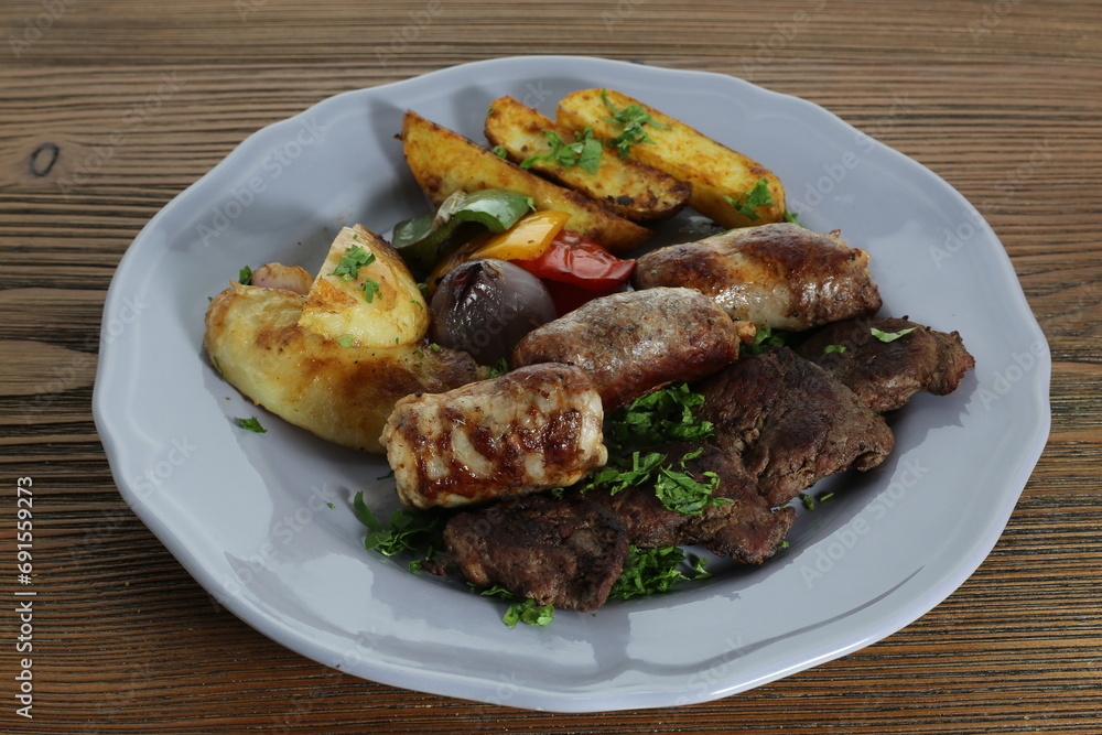 beef tikka kabab and sausage with potato veggies served in dish isolated on table top view of arabic food beef tikka kabab and sausage with potato veggies served in dish isolated on table top view of arabic food
