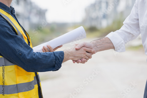 Construction partnership. Engineer handshake with business team contact. Deal building project. Thank you finished done agreement people. Shaking hands greeting meeting agree to hire recruitment. photo