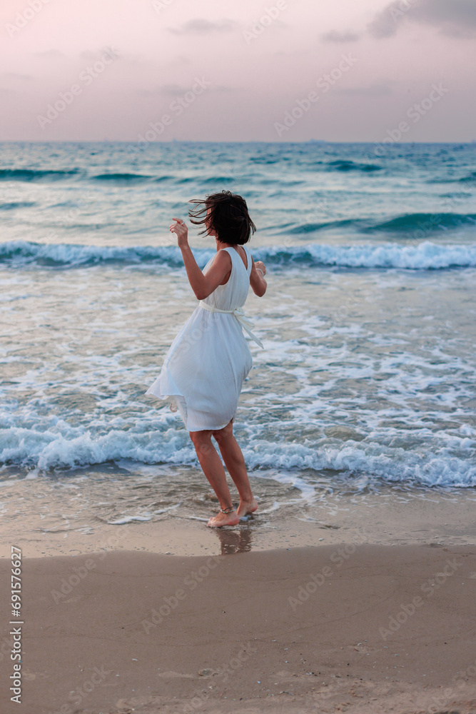 Happy traveler girl in a white summer dress enjoying a tropical paradise beach with turquoise sea. Happy traveler girl in a white summer dress enjoying a tropical paradise beach with turquoise sea.