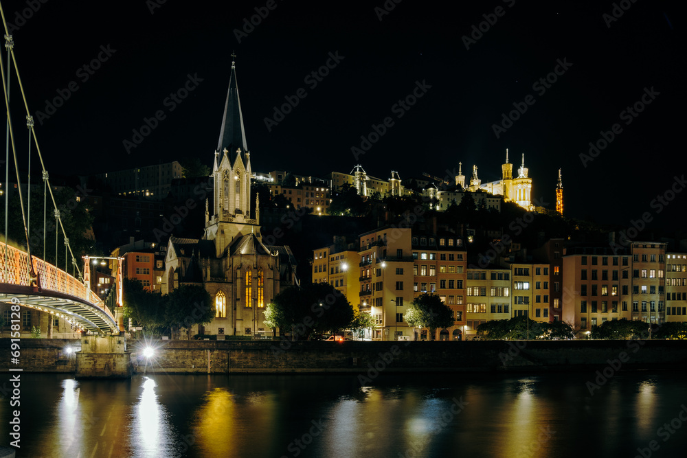 Night view of the Saint George church, the Quais de Saone and the Fourviere Basilica from a footbridge over the river in Vieux Lyon, the old town of Lyon (France)