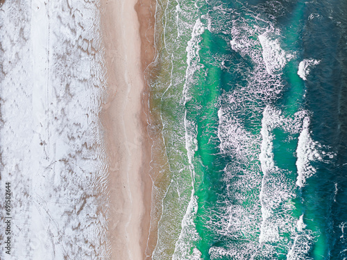 Aerial view of Baltic sea with snowy beach at winter.
