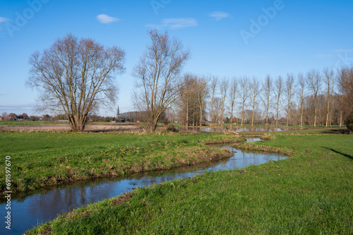 Bending creek through the wetlands and meadows at the Flemish countryside around Imde, Belgium