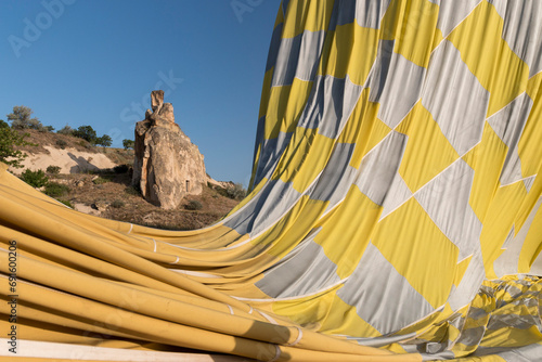 deflating hot air balloon with a fairy chimney in the background, Cappadocia, Turkey photo