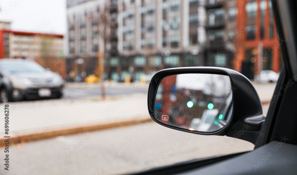 car mirror reflecting cityscape, symbolizing travel, reflection, urban lifestyle, and exploration. Blurred background