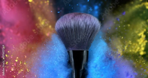 Super slow motion macro of makeup brush with flying rainbow colorful cosmetic product powder dust glitter particles splash explosion isolated on dark background. photo