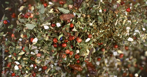 Super slow motion macro of falling heap of granulated rough crystal salt, peppercorn and other mixed herbal spices with flying grains at 1000 fps. photo