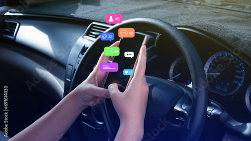 Woman using social media and digital online marketing concepts on mobile phones with icons such as notifications, messages, comments on the smartphone screen in car. © rawintanpin