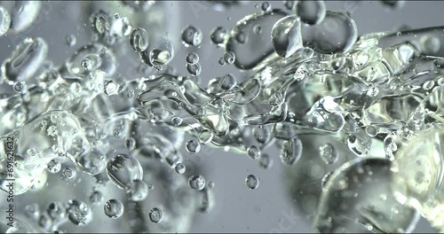 Slow motion macro of floating micro particles molecules in liquid are analyzed with microscope by chemist during innovative new medical research and analysis in scientific pharmaceutical laboratory. photo