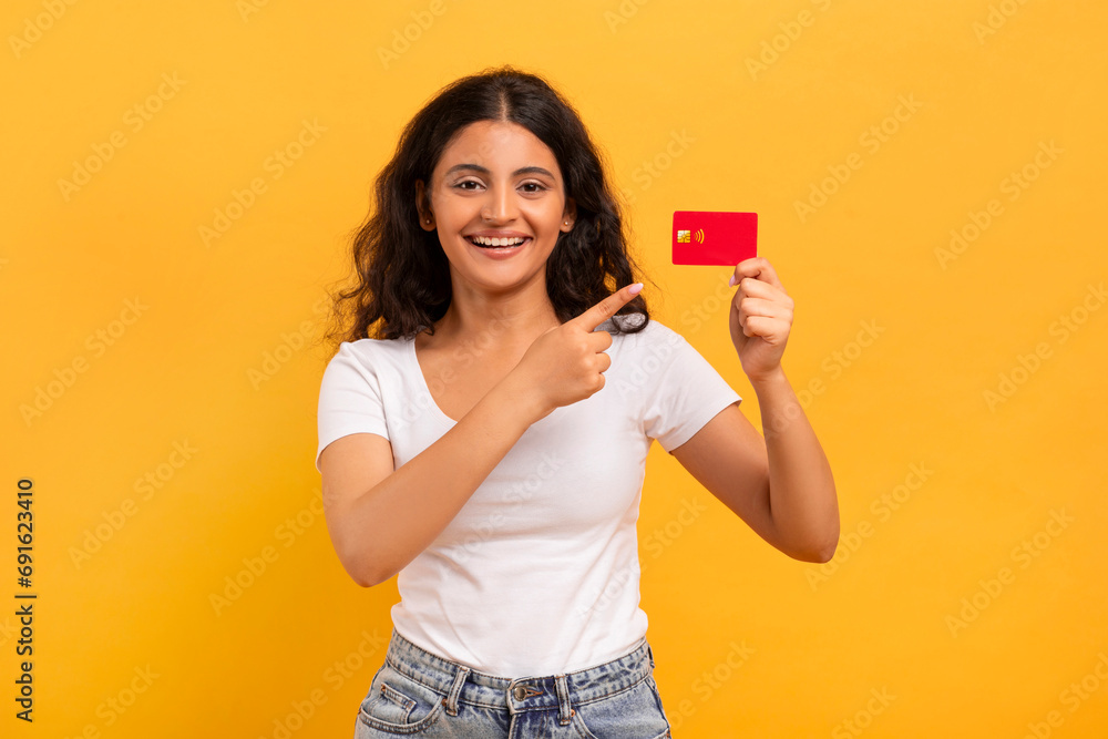 Positive young indian lady showing bank credit card Positive young indian lady showing bank credit card
