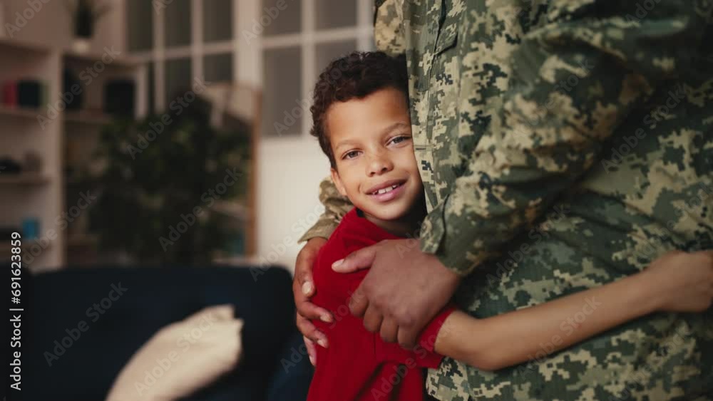 Boy hugging dad in military uniform and smiling, greeting father's comeback