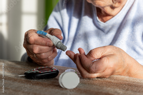 starsza kobieta bada poziom cukru we krwi photo