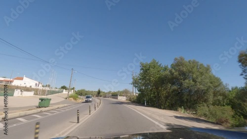 First person view, FPV, from dashcam of car driving along the Algarve Coast in Portugal, driving on the highway towards Faro. Road trip video in POV, with blue sky photo