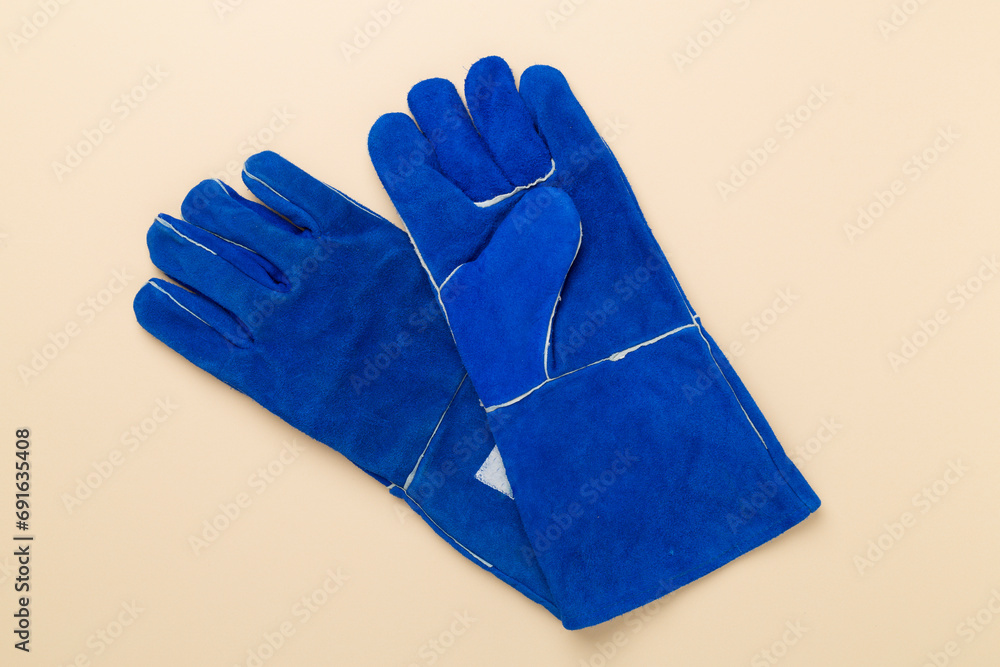 Blue construction gloves on color background, top view Blue construction gloves on color background, top view