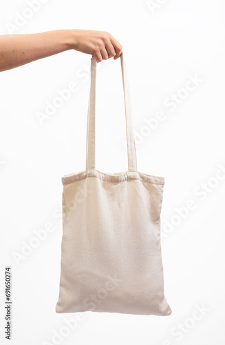 Hand holding tote bag mock up, isolated on white background. Organic natural shopper