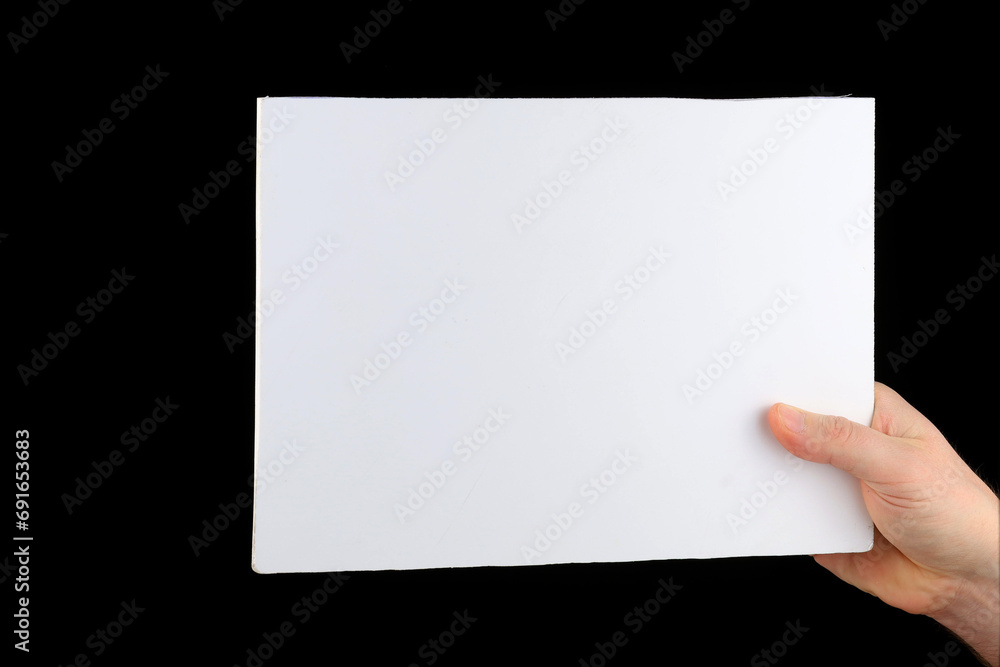 A hand holds a blank sheet of paper. A hand holds a blank sheet of paper.