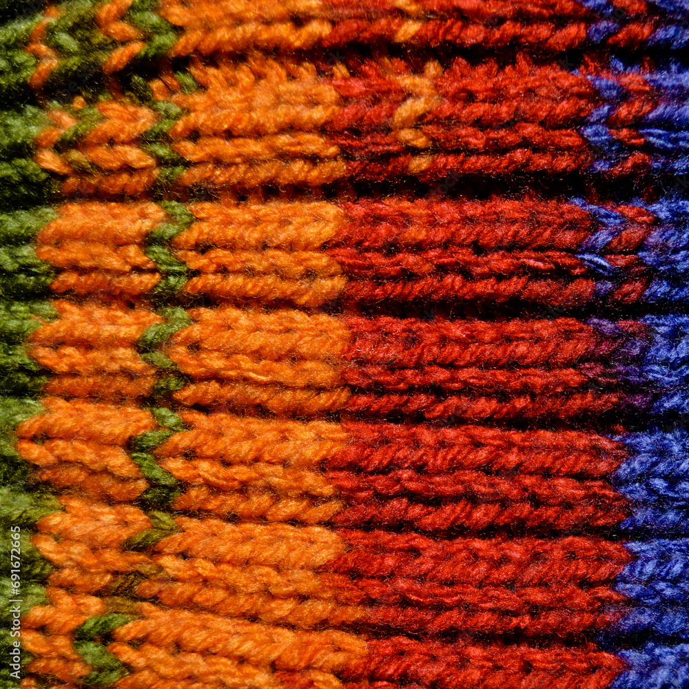 Handmade knitted fabric red blue and orange wool background texture