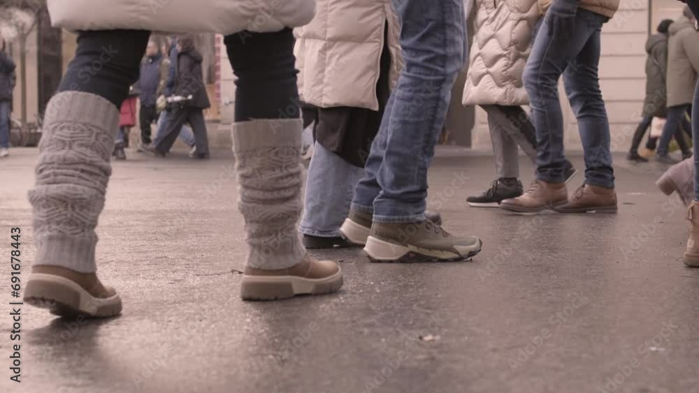 Human legs close up. Many people walk across the street. Urban traffic of people. People wearing winter boots. Feet close up. Slow motion. Autumn winter season. Unrecognizable persons walking street Human legs close up. Many people walk across the street. Urban traffic of people. People wearing winter boots. Feet close up. Slow motion. Autumn winter season. Unrecognizable persons walking street