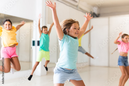 Portrait of satisfied boys and girls jumping having fun after dance class