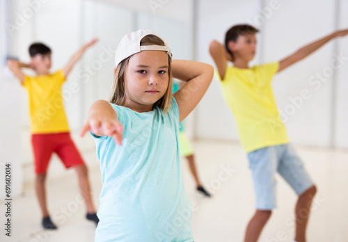 Girl in white cap dancing hip-hop with his mates during groung dance class. photo