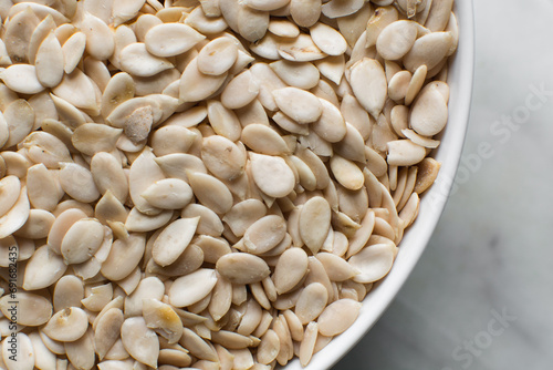 nigerian egusi seeds in a white bowl, shelled melon seeds in a bowl, nigerian melon seeds, pumpkin seeds for cooking photo