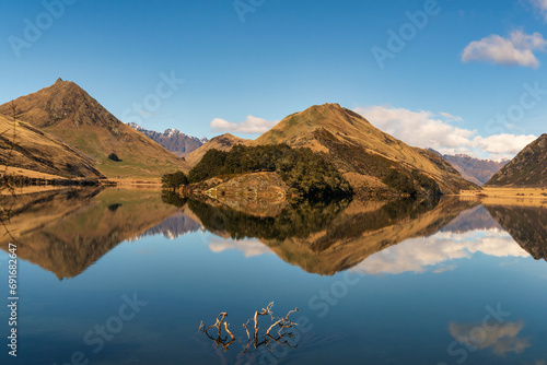 Crystal clear reflection on the very still water moke lake in the mountains near queenstown