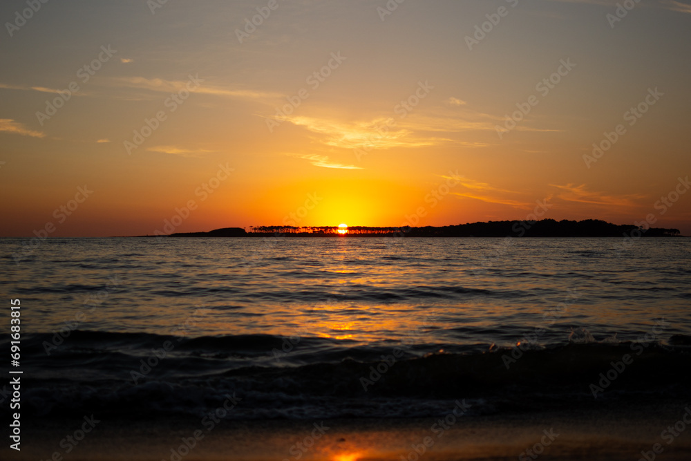 Coastal sunset in Uruguay with orange sky and waves