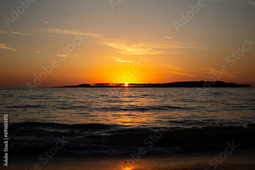 Coastal sunset in Uruguay with orange sky and waves