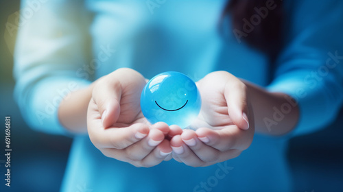 Hands holding blue happy smile face for medical care concept. mental health positive thinking