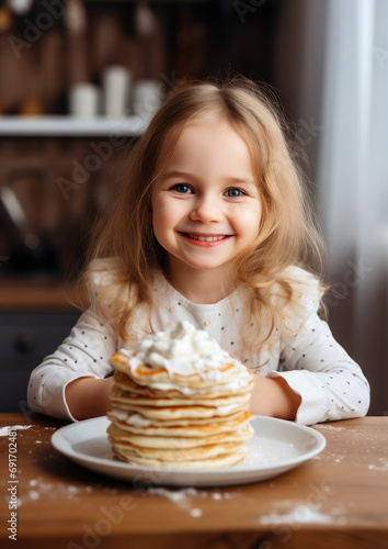 cute little smiling girl eating pancakes  Maslenitsa  holiday  breakfast  lunch  hot crepes  dinner  child  kid  daughter  kitchen  food  holiday  carnival  delicious treat  childhood  portrait  joy