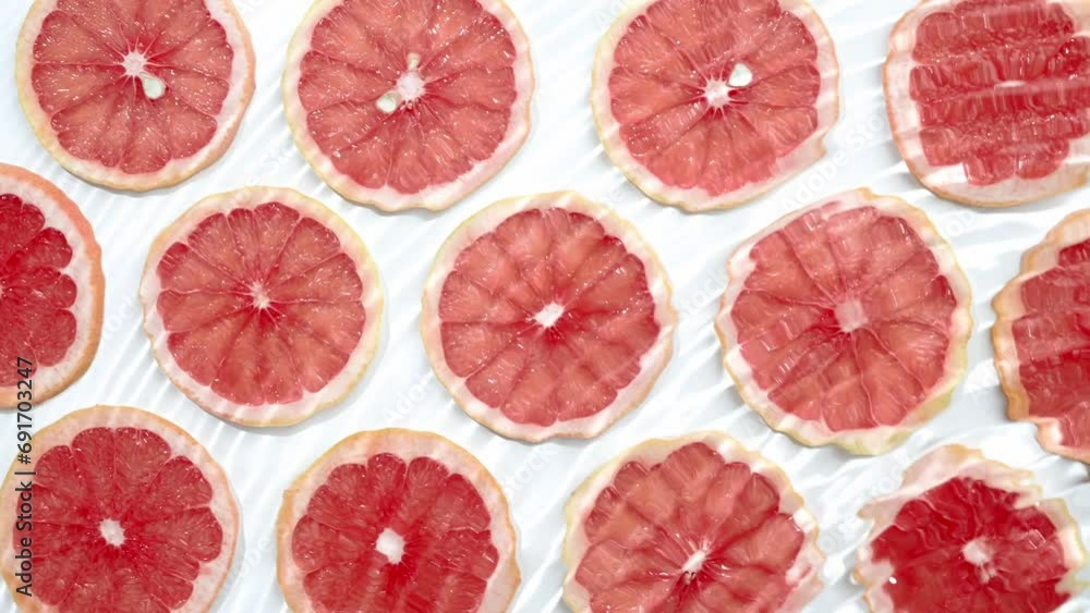 Slice of grapefruit underwater or in water with splashing and droplet top view flat lay on white background. Slice of grapefruit underwater or in water with splashing and droplet top view flat lay on white background.