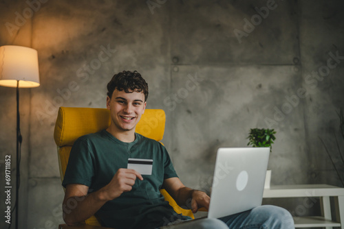 teenager young man at home use credit card shopping online e-banking photo
