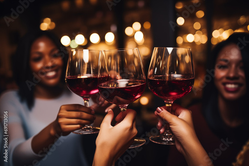 Mujeres brindando con copas de vino tinto en bar photo