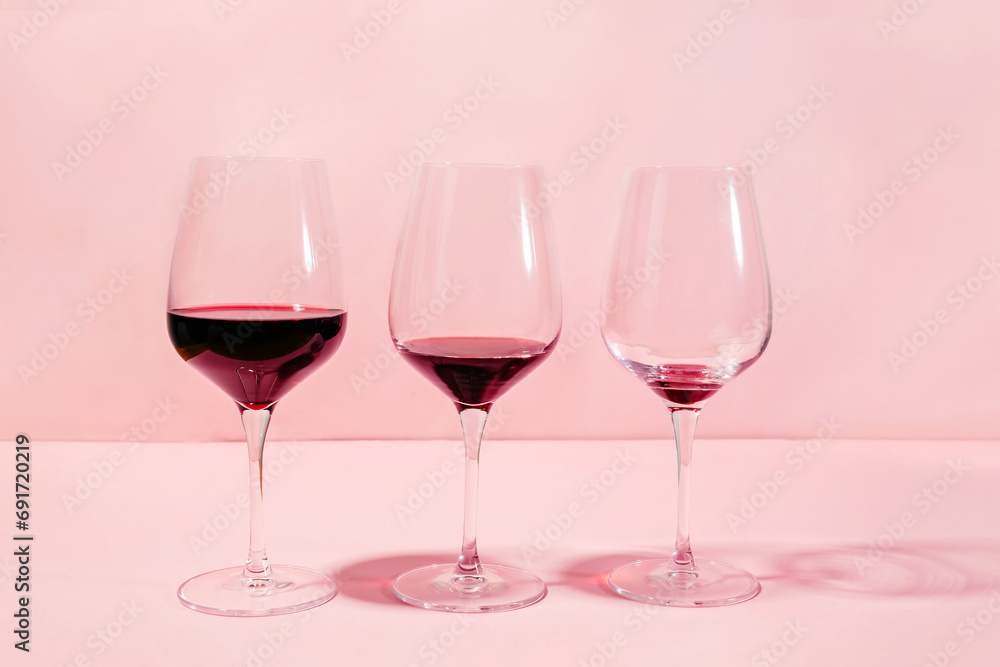 Mindful drinking and alcohol cutback concept. Three glasses with lowering levels of red wine poured - obrazy, fototapety, plakaty 