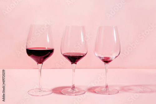 Mindful drinking and alcohol cutback concept. Three glasses with lowering levels of red wine poured