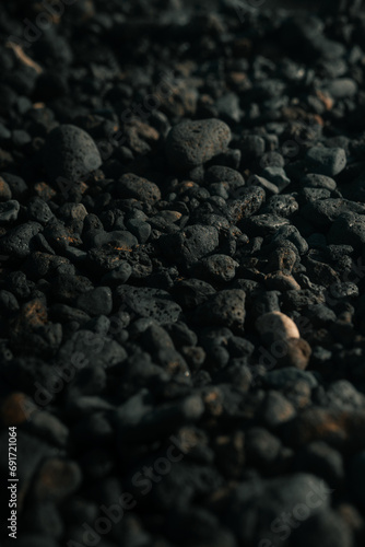 Black volcanic rocks, porous stones on a beach, pebbles,