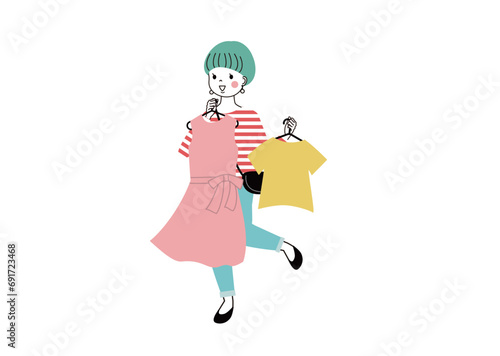 ショッピング　洋服を体にあてながら選んでいる笑顔の女性