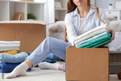 Young woman packing clothes...