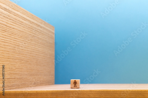 そびえ立つ木のカベの前にいる人のウッドキューブの青い背景 photo