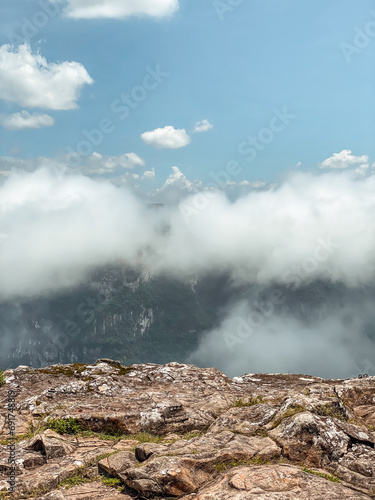 Fog and clouds in the peak of a green mountain with blue sky and good conditions
