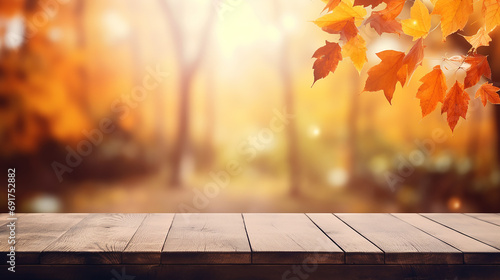 orange leaves on wooden table with blurred autumn background